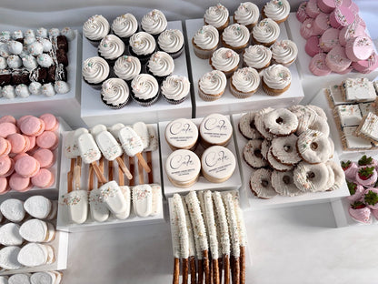 Assorted desserts including cupcakes, donuts, and cookies on a white surface.