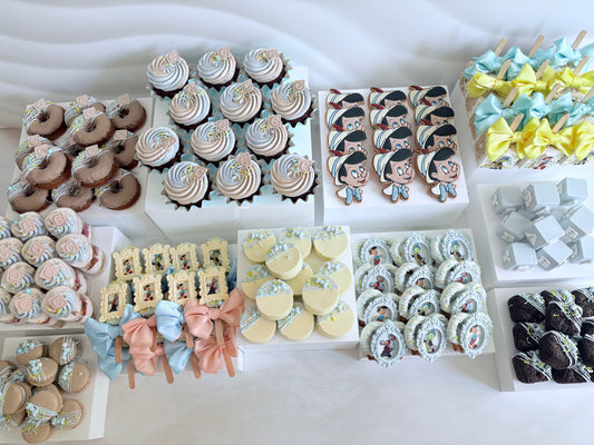 Assorted desserts including cupcakes, cookies, and donuts on a white surface.