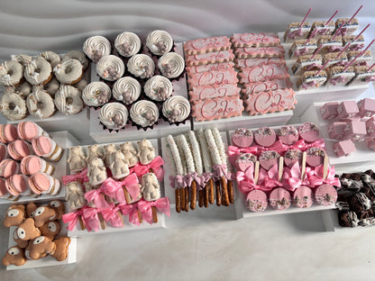 Assorted pastries including donuts, cookies, and cakes displayed on a marble surface.