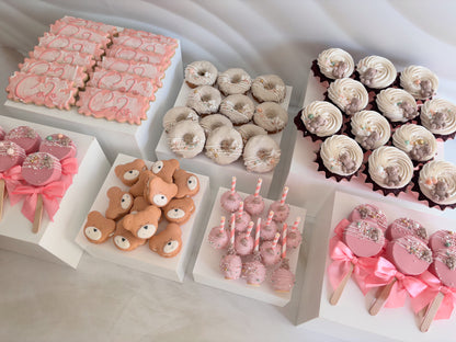 Assorted desserts including donuts, cupcakes, and cookies on a white surface.