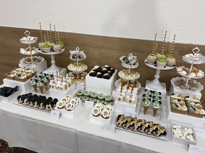 Dessert table with various pastries and treats on tiered stands.